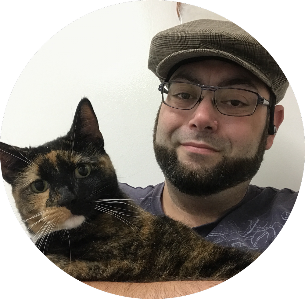 Myk, a pet care professional at Paw Prints NYC, smiling and holding his cat Zelda